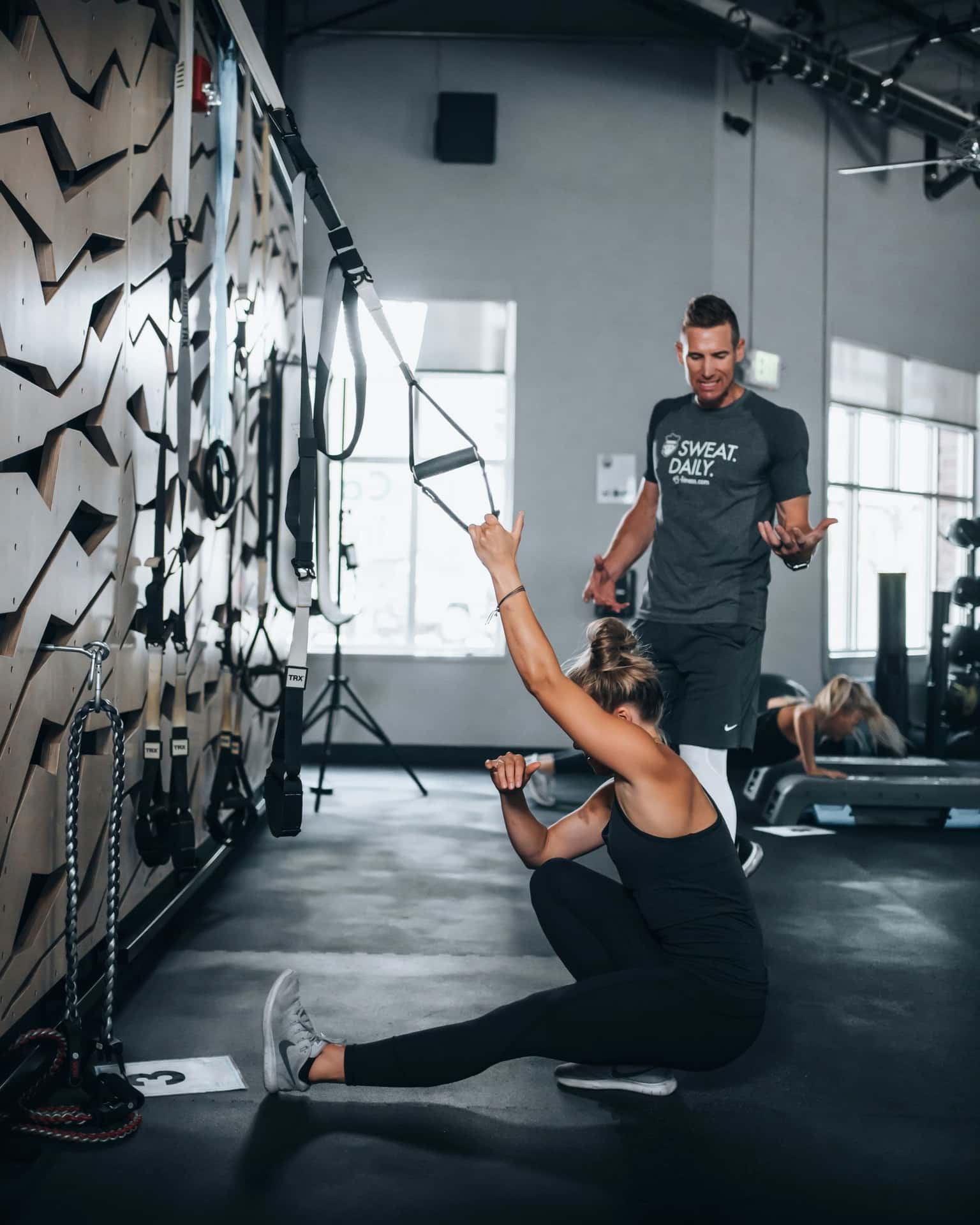 A coach encouraging a client during a cable exercise